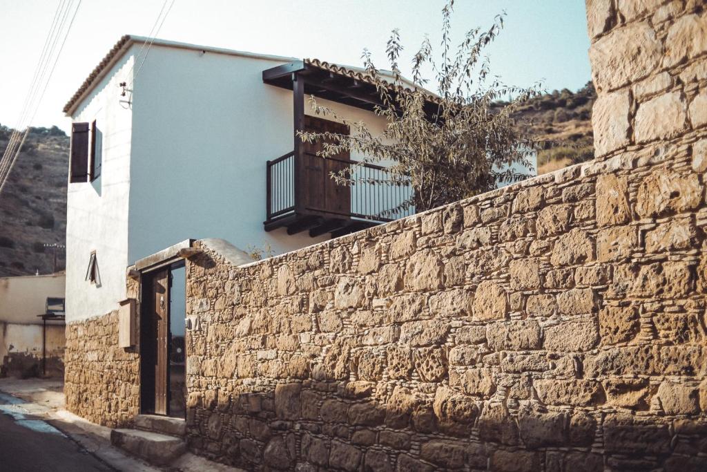 a building with a balcony on top of a stone wall at CASAVERO in Oroklini