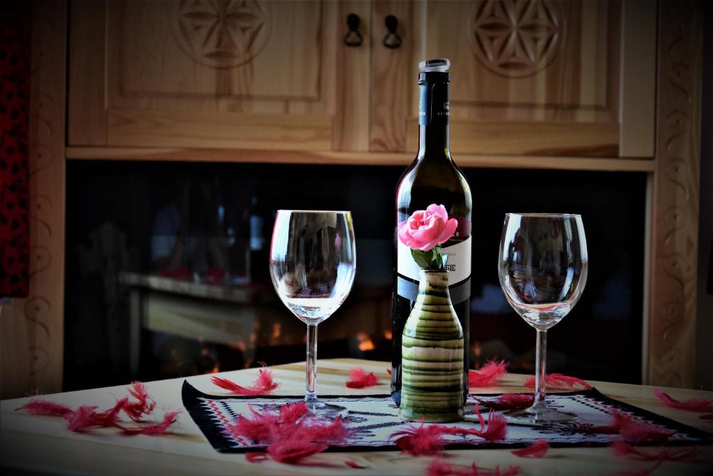 コシチェリスコにあるMagiczne Korale - Kameralne miejsce na odpoczynek dla Dorosłych - Adult Onlyのワイン1本とワイングラス2杯(テーブル上)
