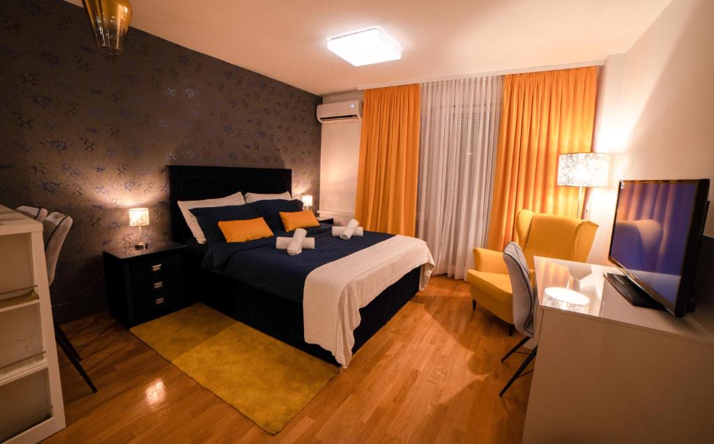 a bedroom with a bed and a desk and a television at Jacuzzi studio apartman Mare's in Zagreb