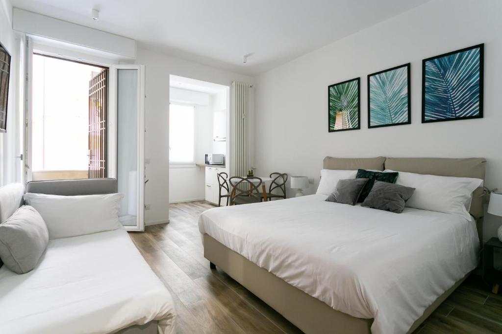 two beds in a bedroom with white walls at Milanofierapartments in Milan