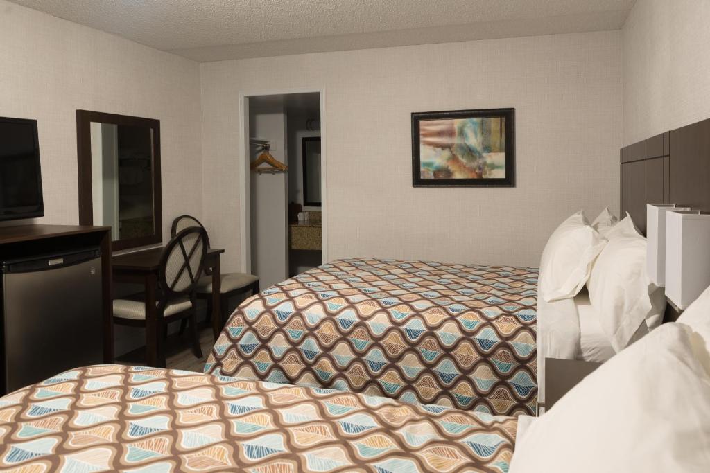Postel nebo postele na pokoji v ubytování Deluxe Inn