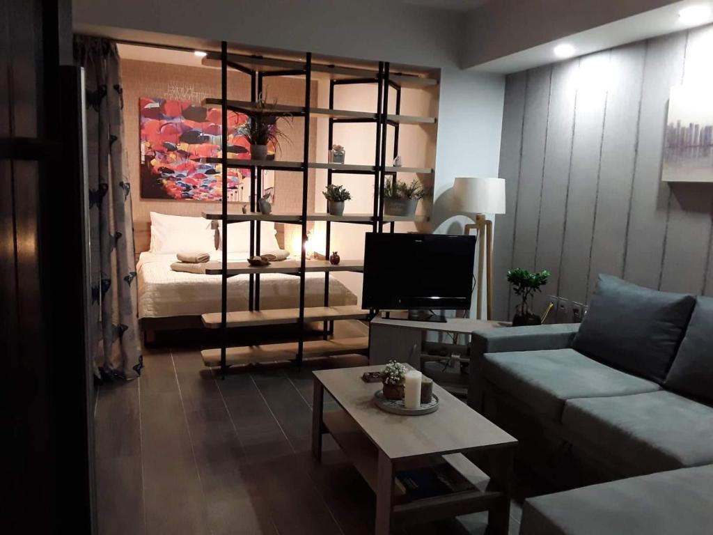 uma sala de estar com um sofá e uma televisão em Apartment 22 em Alexandroupoli