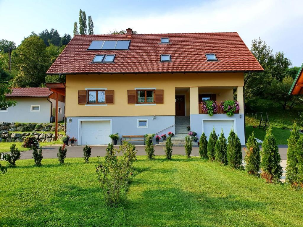 a house with a red roof and a green yard at Ferienwohnung Wruss in Gamlitz