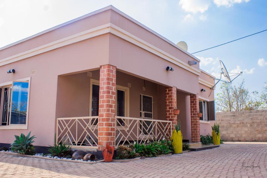 a pink house with a brick at JMV apartments in Kasama