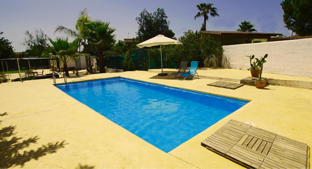 einen Pool im Hinterhof mit Sonnenschirm in der Unterkunft Casa Mallaeta in La Pobla de Vallbona