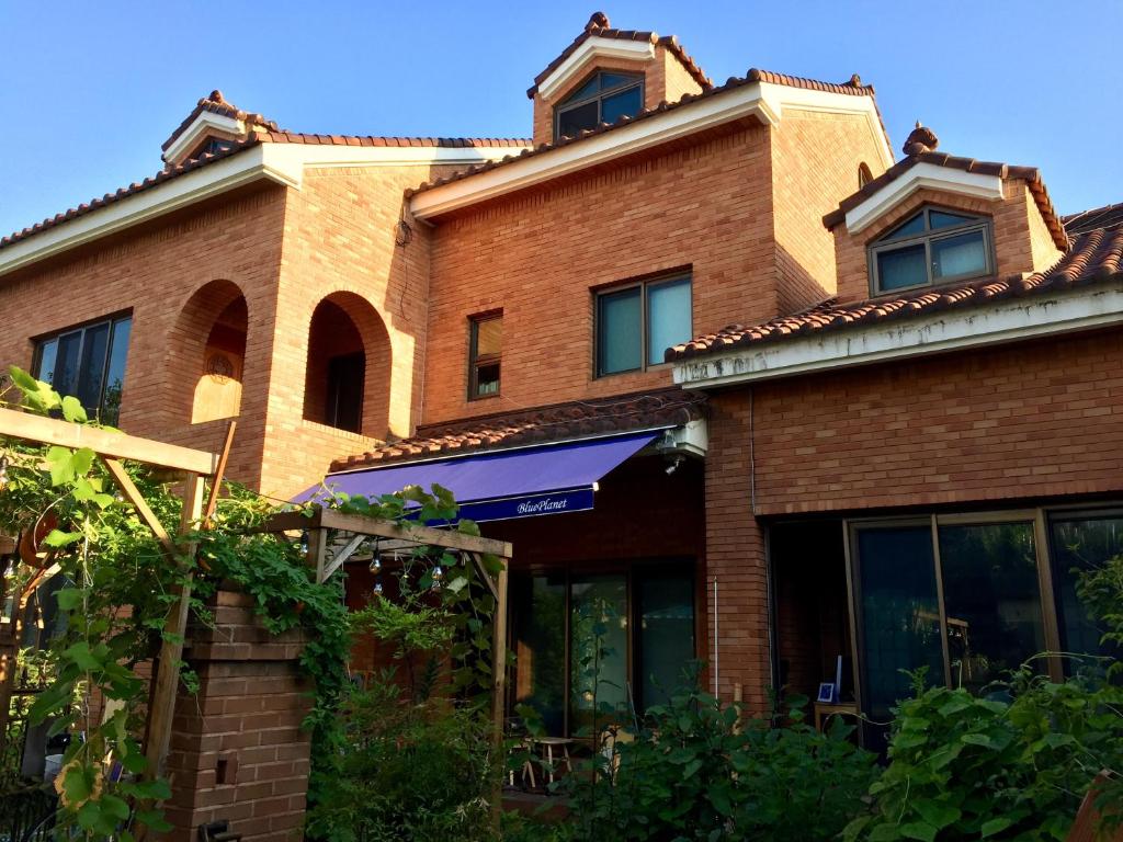 a red brick building with a blue awning at BluePlanet in Gyeongju