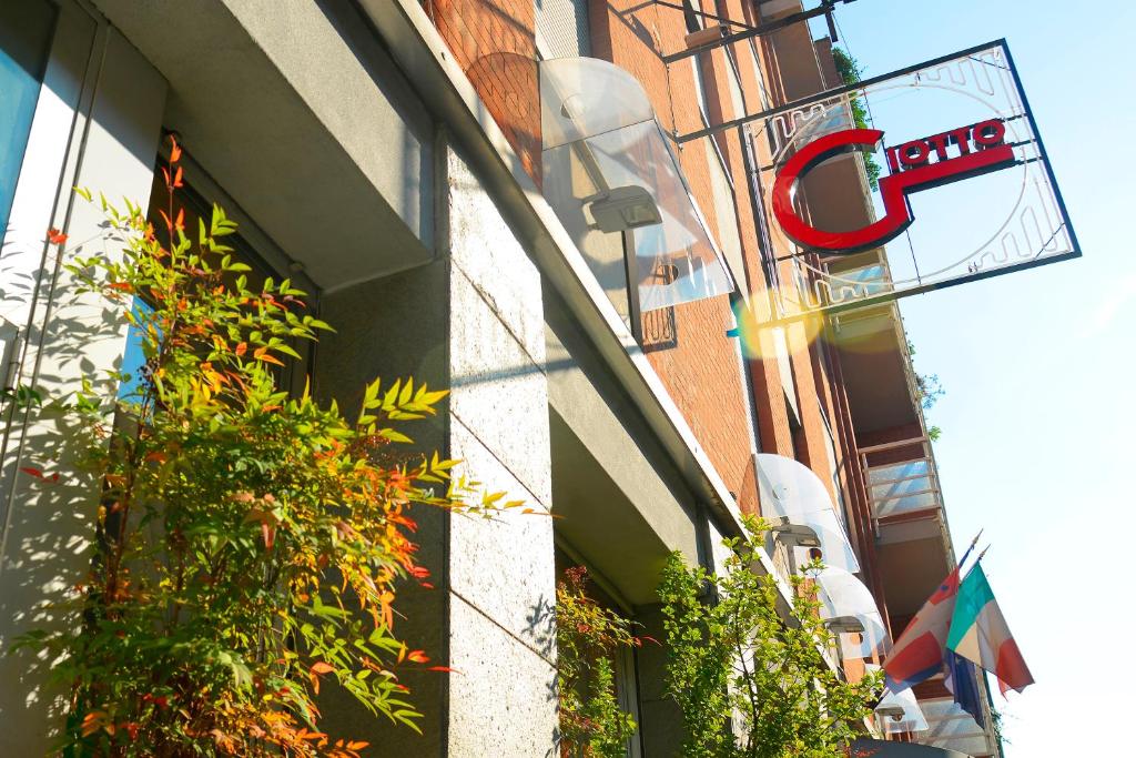 una señal en el lado de un edificio con plantas en Hotel Giotto, en Turín