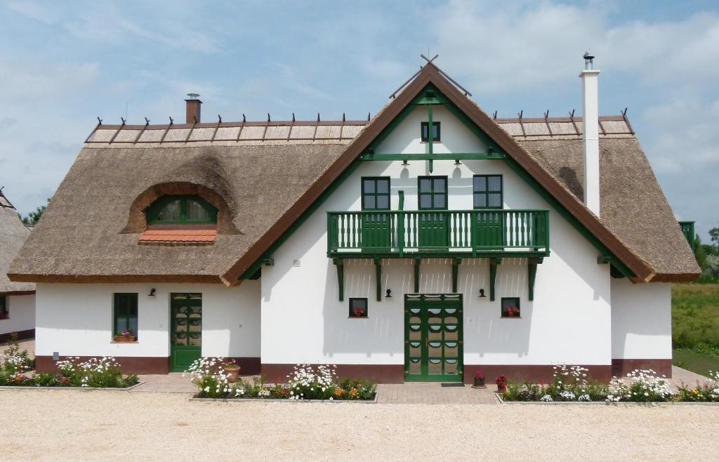 una gran casa blanca con techo de gambrel en Antal-tavi Fogadó és Horgászparadicsom, en Szentes