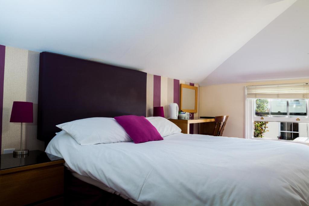 a bedroom with a large white bed and a window at Duke of Buckingham in Portsmouth