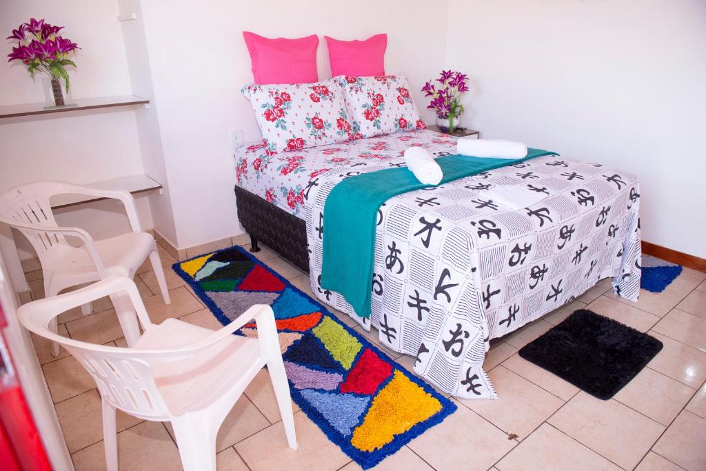 1 dormitorio con 1 cama, mesa y sillas en Excelente Apartamento - Família Mangas Monteiro, en Macapá