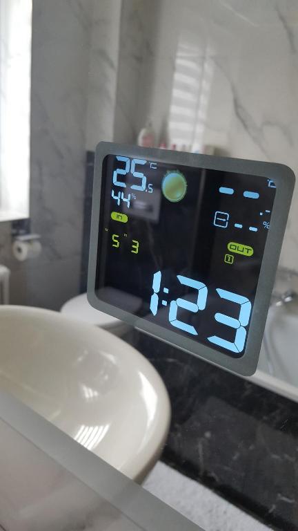 a clock on a bathroom counter next to a sink at Unterkunft A.Lambrecht in Oberhausen
