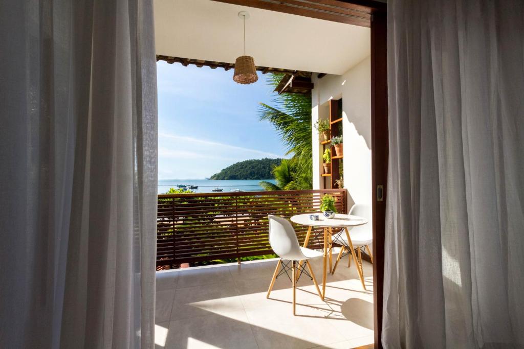 a balcony with a table and a view of the ocean at Pousada Catarina in Paraty