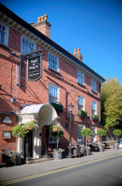 a brick building with a sign in front of it at Angel @ KingSt in Knutsford