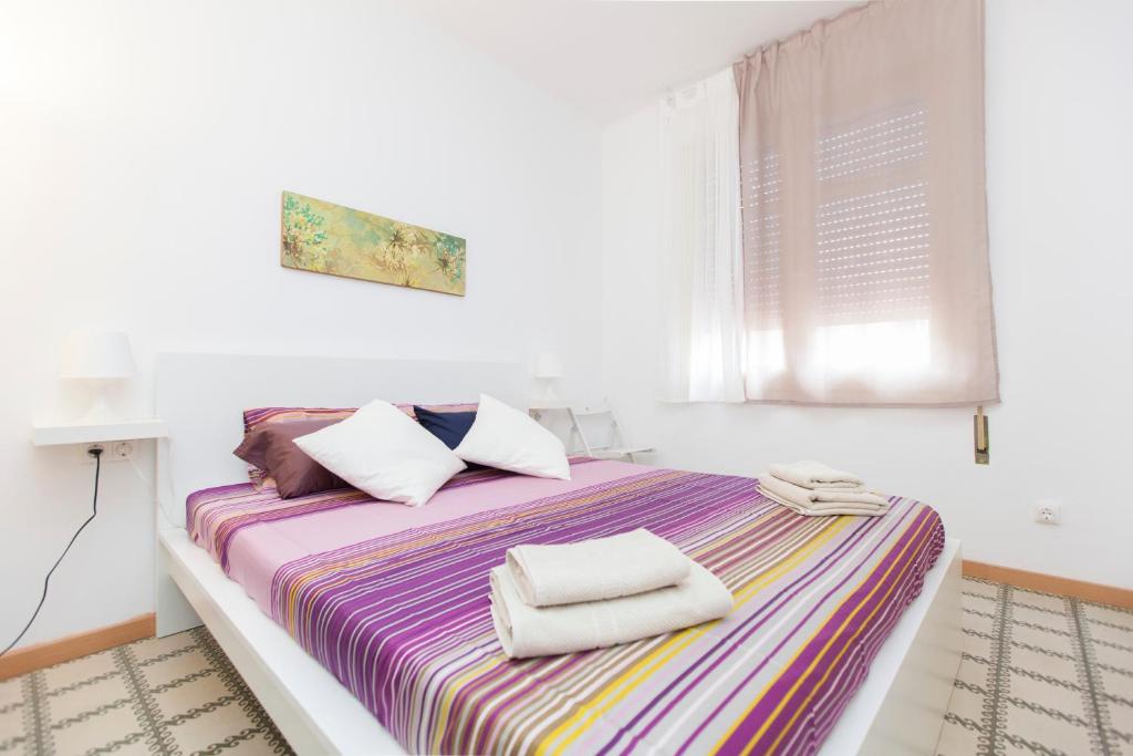 a white bedroom with a large bed with towels on it at Stay Barcelona Plaza España Fira in Barcelona