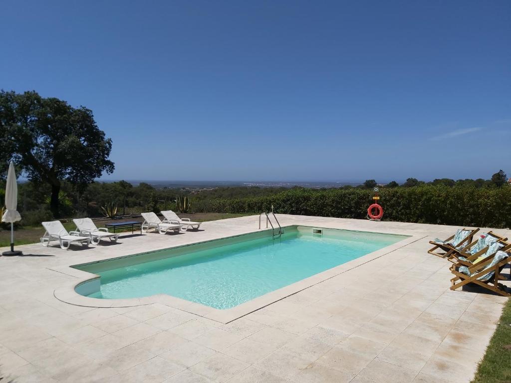 einen Pool auf einer Terrasse mit Stühlen in der Unterkunft Monte da Corte by Hi Alentejo in Santiago do Cacém