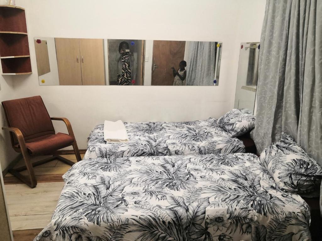 ウィントフークにあるLEONE PARISのベッドルーム1室(ベッド1台、椅子、鏡付)