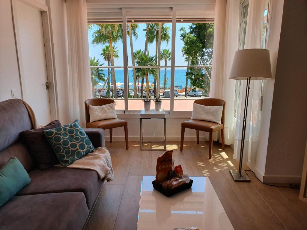 a living room with a couch and a view of the ocean at Piso Paseo Marítimo in Benalmádena