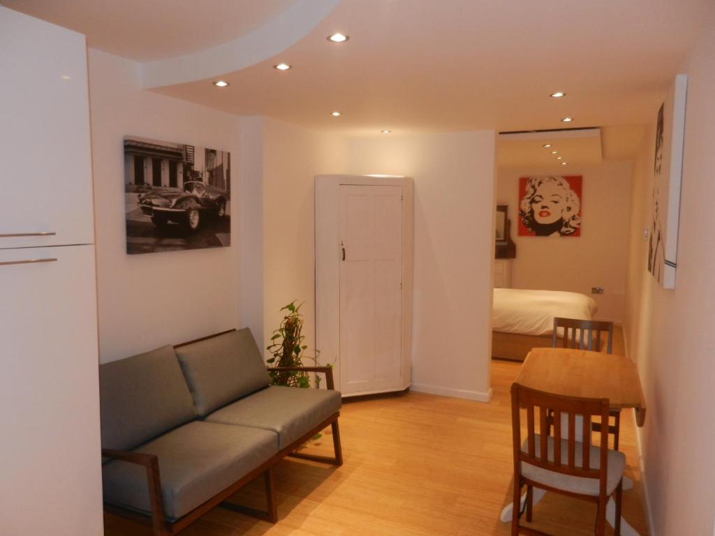 a living room with a couch and a table and a bed at Boynton Hill B&B in Nottingham