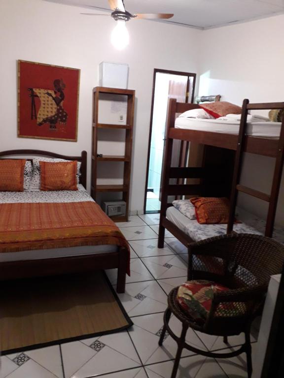 Pokój z 2 łóżkami piętrowymi i krzesłem w obiekcie Suite de Lane e Mu w mieście Abraão