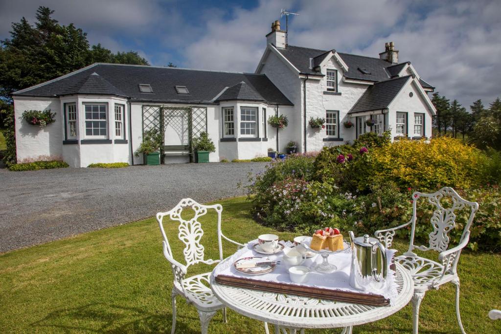 een tafel en stoelen voor een huis bij Kilmeny in Ballygrant