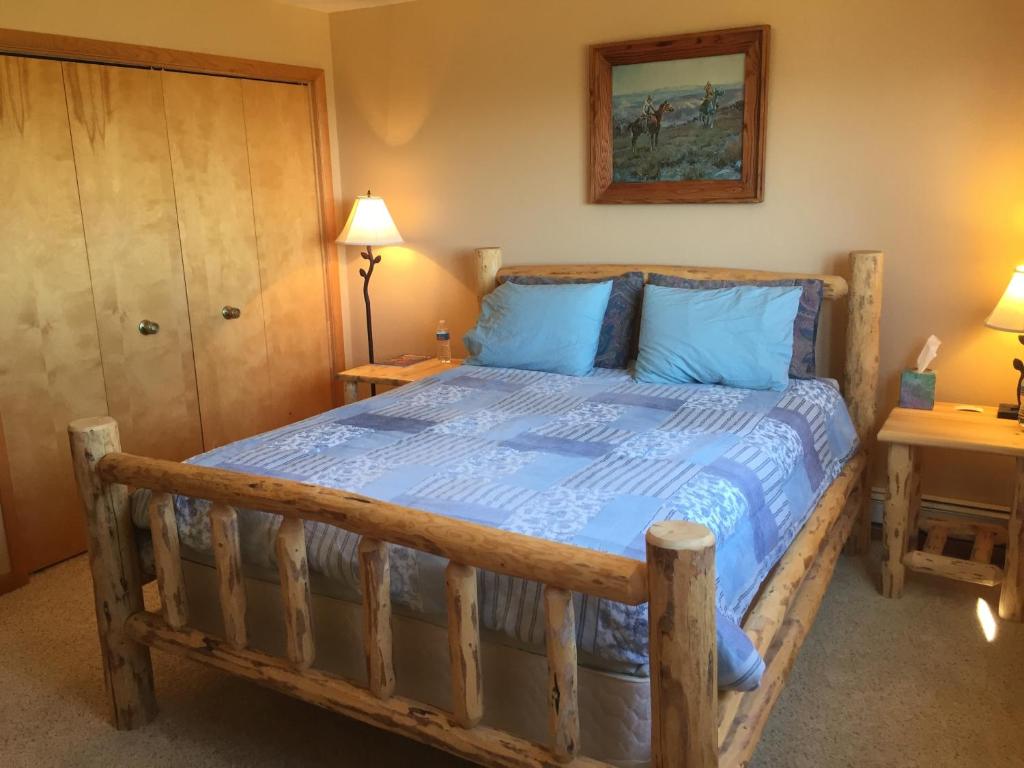 una camera con letto in legno e cuscini blu di Fish Creek House Bed & Breakfast a Silver Star