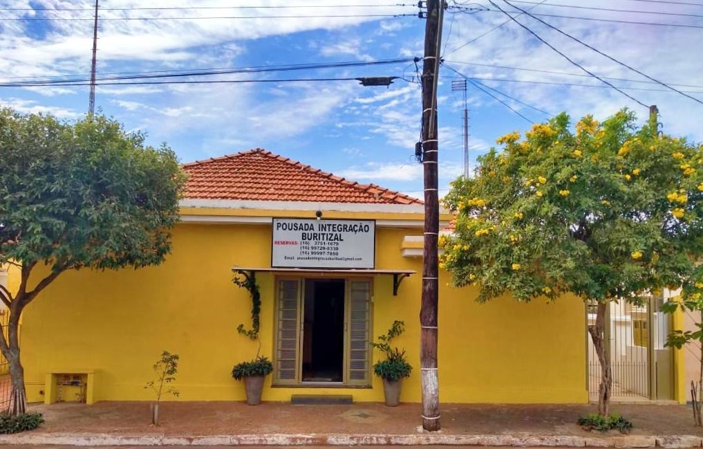 ein gelbes Gebäude mit einem Schild davor in der Unterkunft Pousada Integração Buritizal in Buritizal