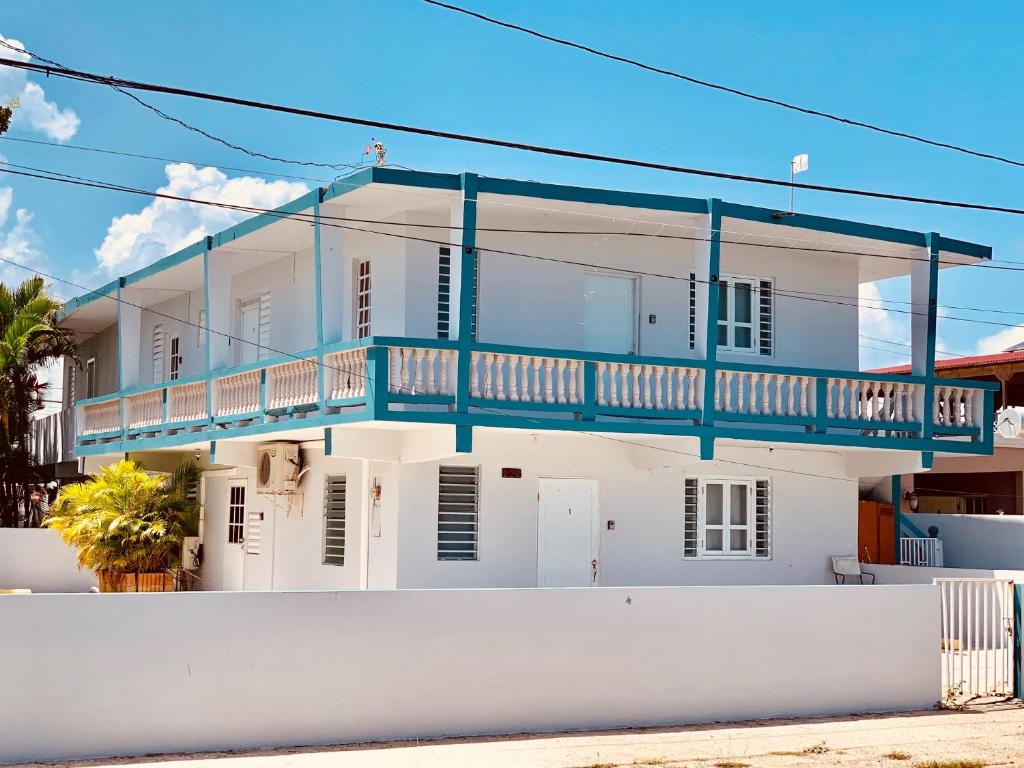 Una casa blanca con un balcón azul. en Coastal Express Inn & Suites #1 at 681 Ocean Drive, en Arecibo