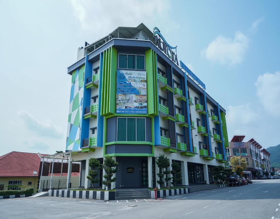 een groen en blauw gebouw aan de straatkant bij Aurora Boutique Hotel in Bahau
