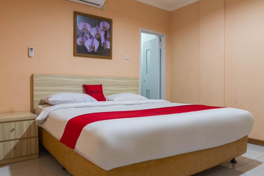 萬隆的住宿－RedDoorz near Istana Plaza 2，一间卧室配有一张带红色毯子的大床