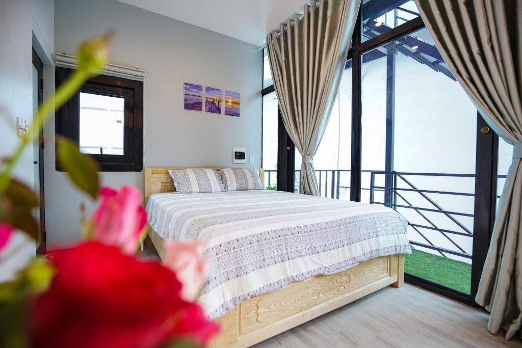 um quarto com uma cama e uma grande janela em Halong bay Almorhome em Ha Long