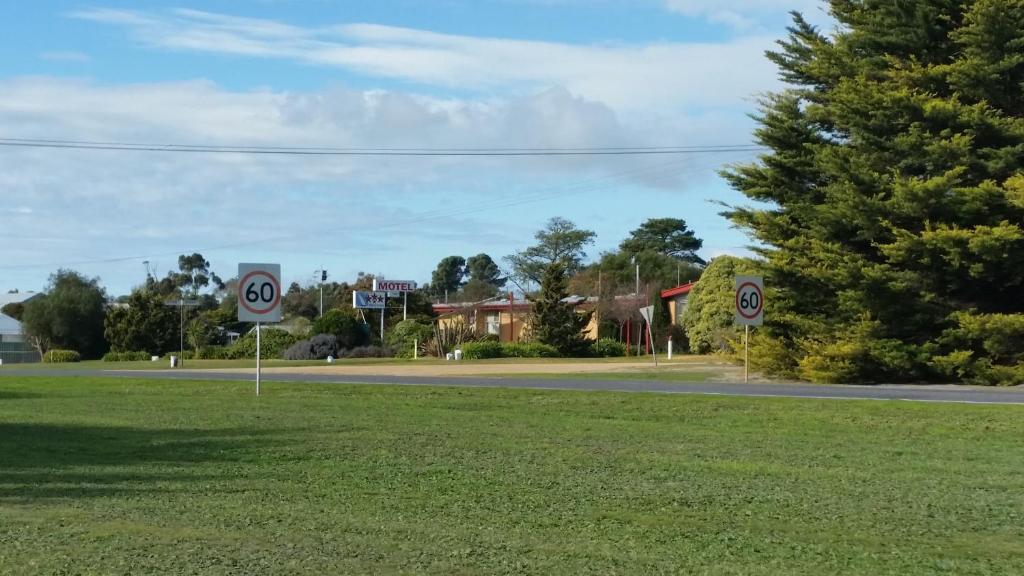 a street with two speed signs in the grass at Lake Bolac Motel in Lake Bolac