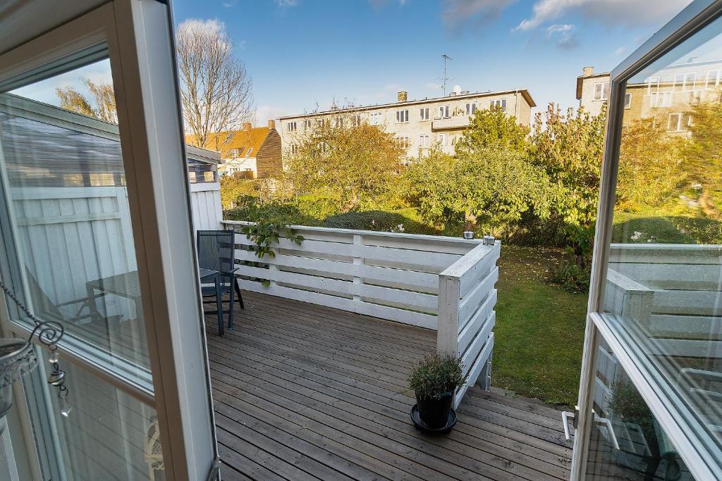 a porch with a white fence and a table and chairs at rækkehus ved amagerstrand in Copenhagen