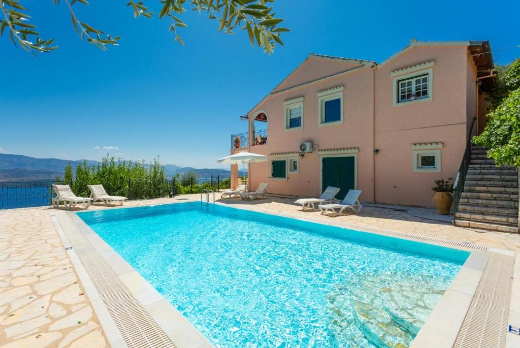 a villa with a swimming pool in front of a house at Villa Eleni in Agnítsini