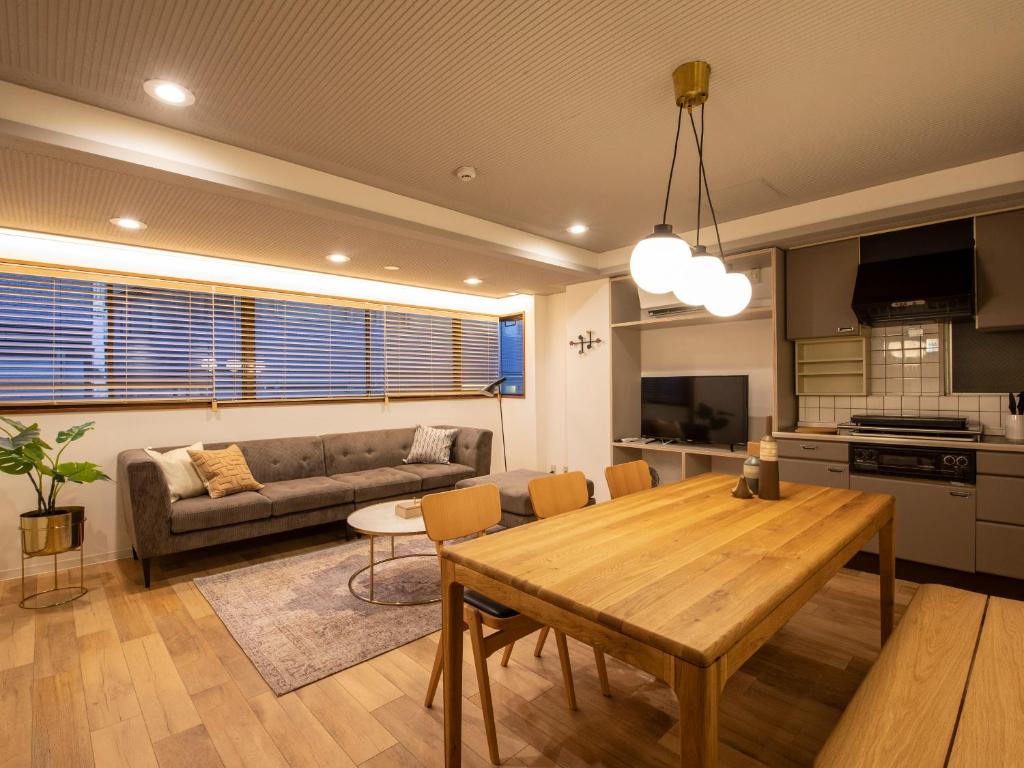 nid OSAKA Atre Nakatsu في أوساكا: غرفة معيشة بها طاولة وأريكة