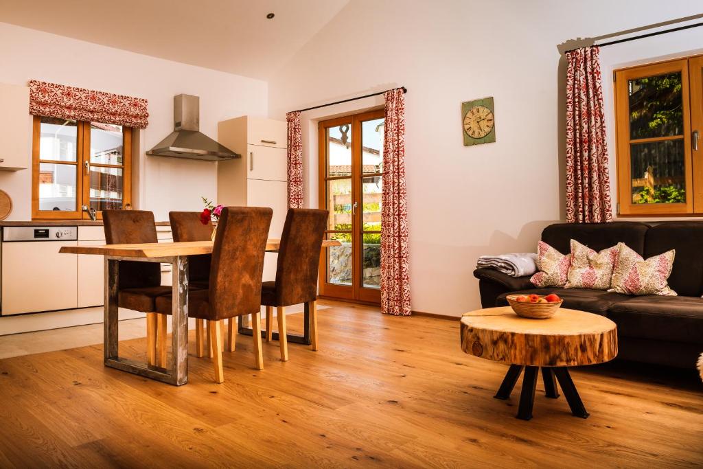 uma sala de estar com uma mesa e um sofá em Ferienwohnung Glaserhäusl am Roßgarten em Schliersee