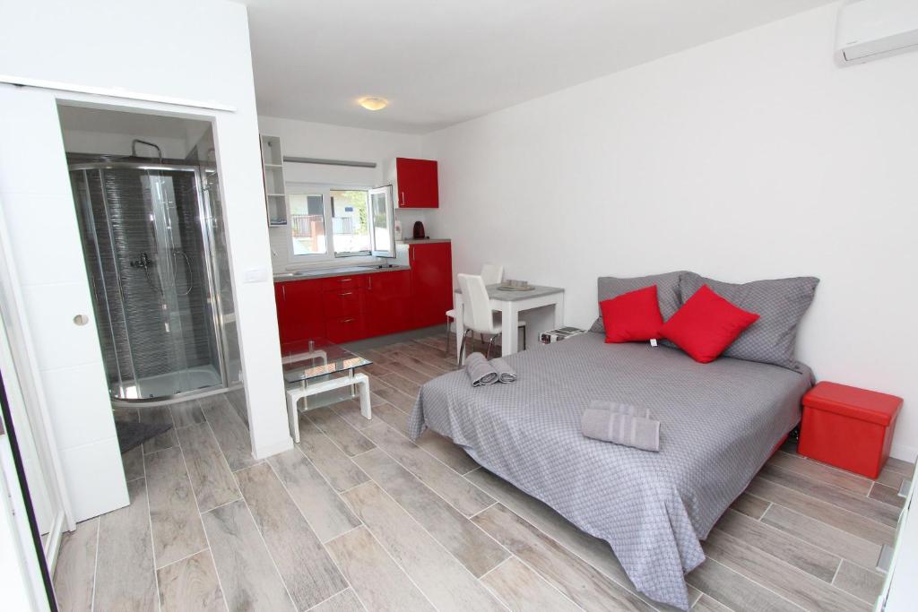 a bedroom with a bed with red pillows on it at Guest House Mafi in Rovinj