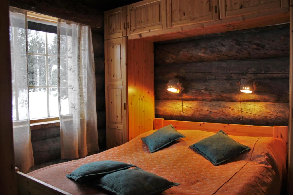 a bedroom with a bed with two pillows and a window at Villa Tunturituuli in Kuusamo