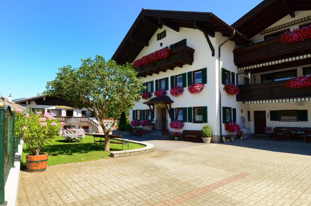 ein großes weißes Gebäude mit Blumen an den Fenstern in der Unterkunft Haus Magdalena in Abtenau