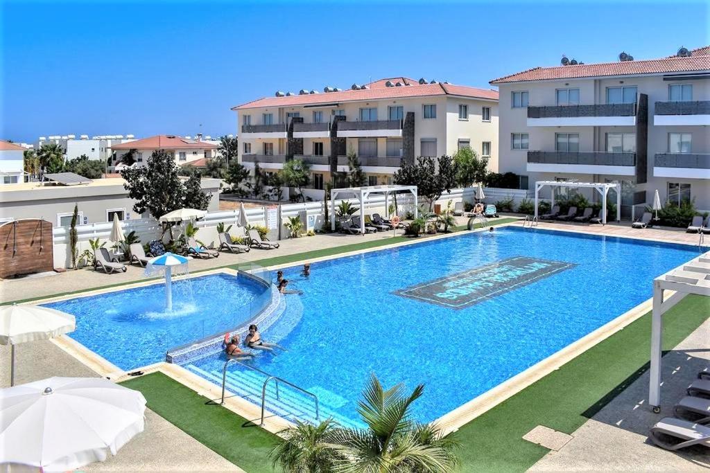 ein großer Swimmingpool mit Menschen in einem Hotel in der Unterkunft Kapparis Apartment Mythical Sands in Protaras