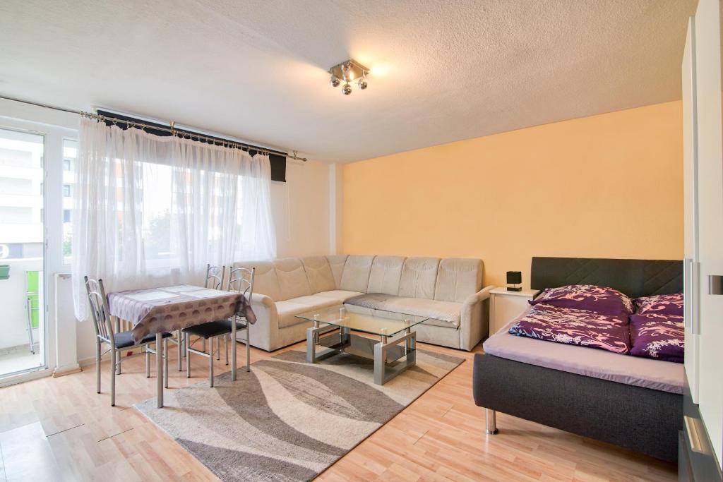 een woonkamer met een bank en een tafel bij Comfortable Homly Apartment in Offenbach