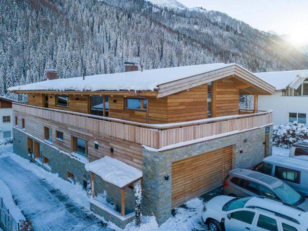 una casa di tronchi con neve sul tetto di Riffelalp Lodge a Sankt Anton am Arlberg