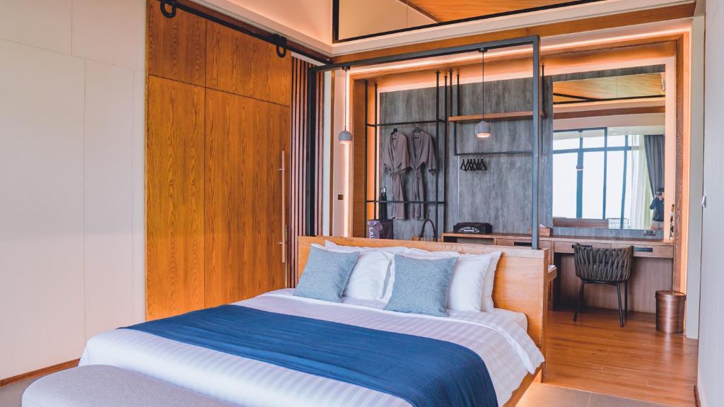 a bedroom with a large bed with blue and white pillows at The Cabin Beach Resort in Haad Rin