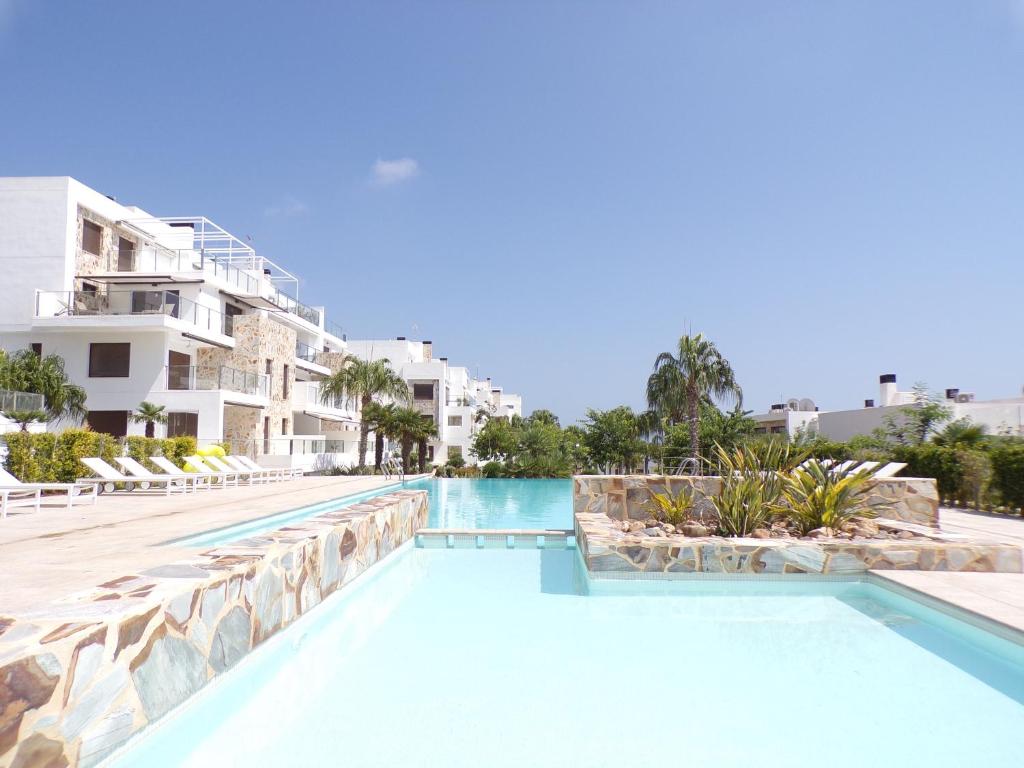 uma piscina num resort com edifícios brancos em 3 Bedroom Luxury Apartment Villamartin em Orihuela