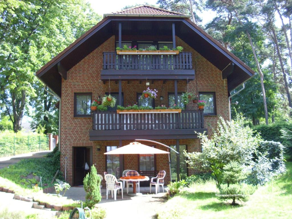 a house with a balcony and a table and chairs at Ferienwohnung direkt am See in Bad Saarow