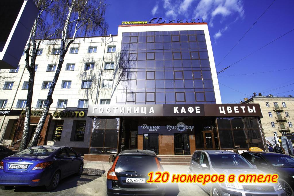 two cars parked in front of a building at Hotel Desna in Bryansk