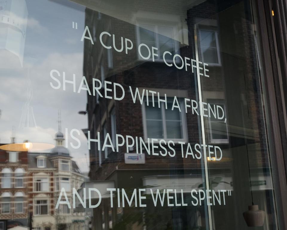 a cup of coffee shared with a friend and time well spent reflected in a window at Milk and cookies in Venlo
