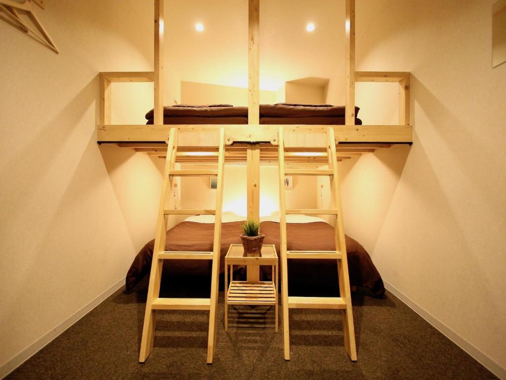 2 literas en una habitación pequeña con una planta en Osaka Guesthouse Nest, en Osaka