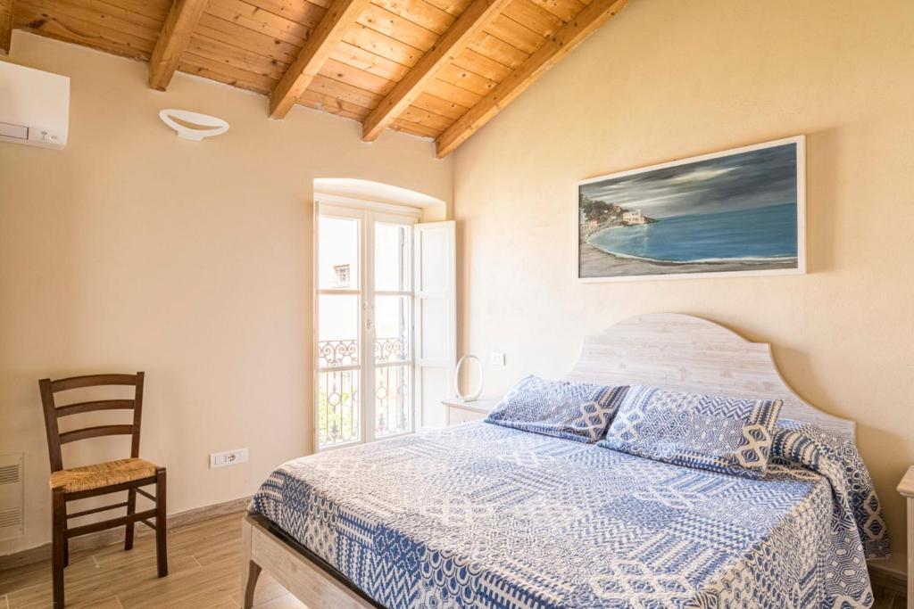 een slaapkamer met een bed, een stoel en een raam bij I Delfini in Levanto