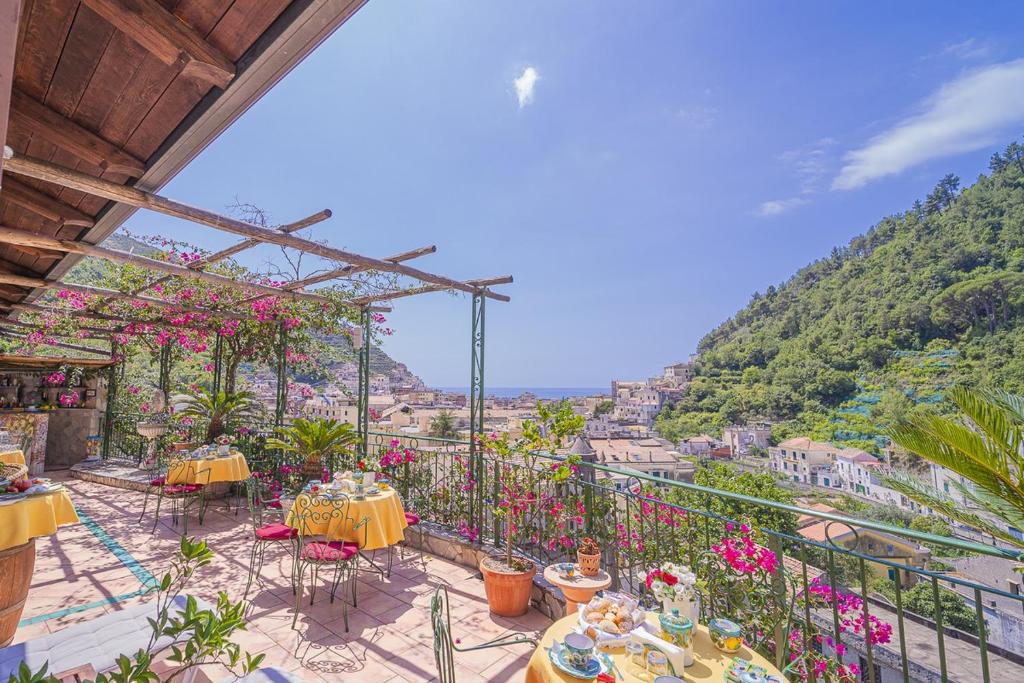 a balcony with tables and chairs and a view at Montagnella Relax in Maiori