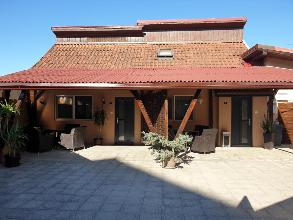 a house with a roof with chairs and a patio at Irina Apartments in Timişoara